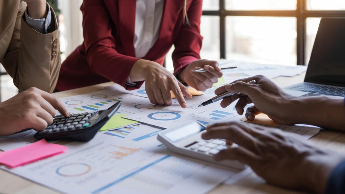 Business partners going over a budget with calculators and printed reports