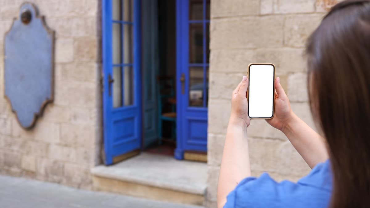Business owner photographing the front door of her office with a smartphone