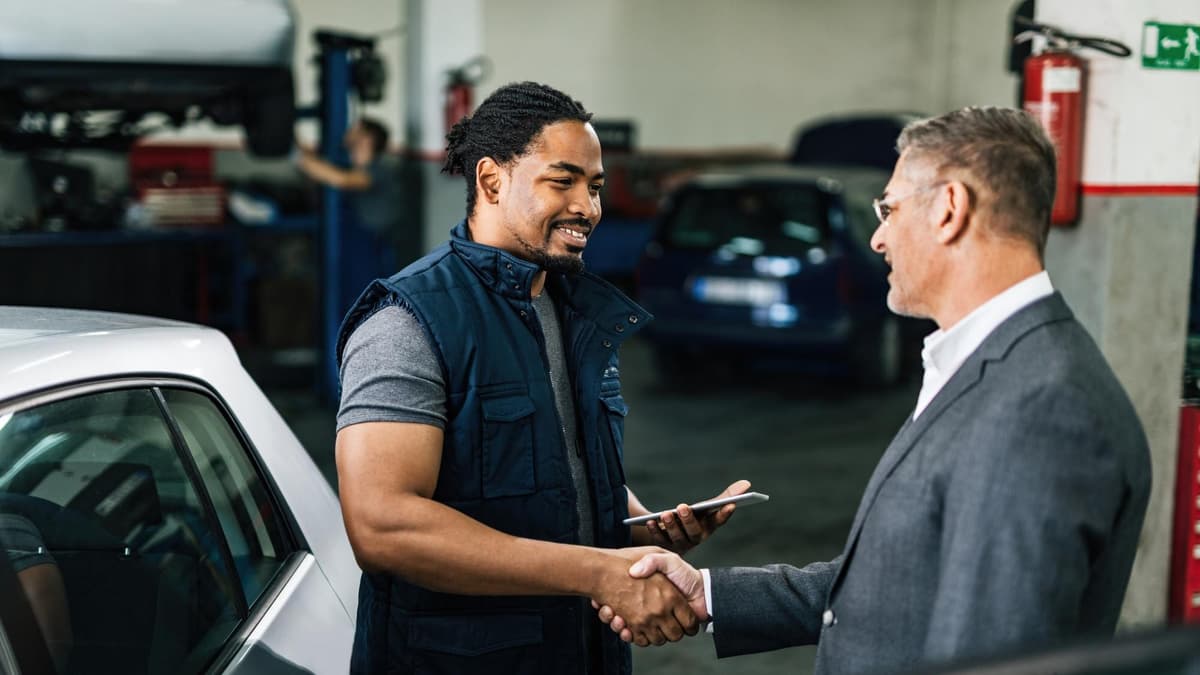Auto repair shop service advisor talking with a customer at the front counter