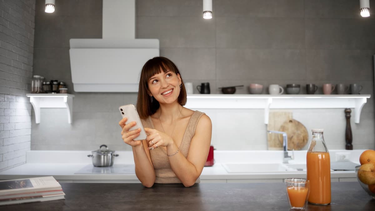 Homeowner searching for a contractor on her phone in her kitchen