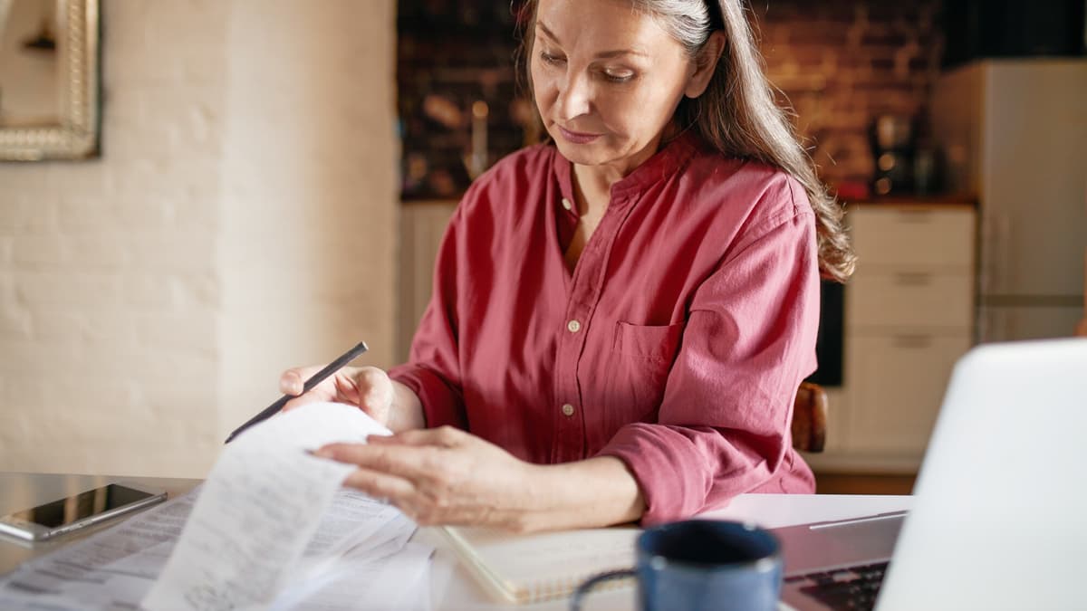 Small business owner checking receipts and invoices at her kitchen table