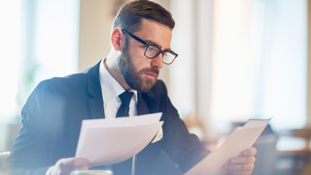 Small business owner reading the terms of an SEO contract at a cafe table