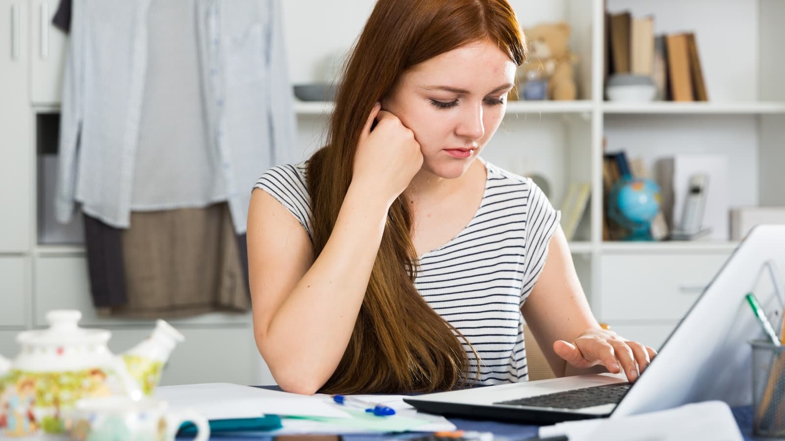 Small business owner reviewing the hidden costs of cheap web design on a laptop at her desk