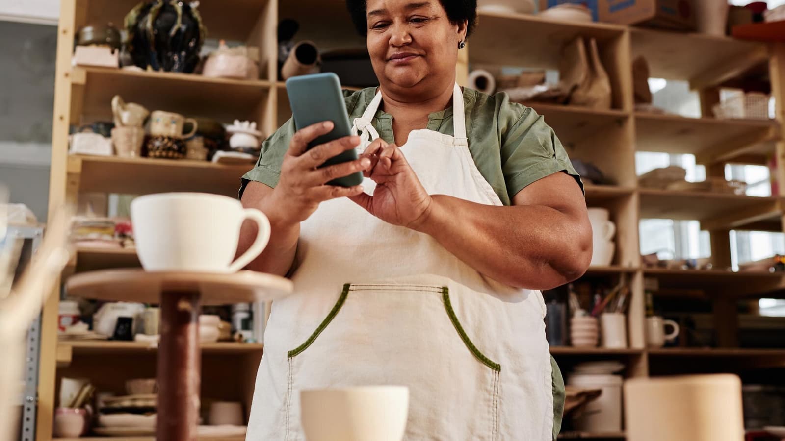 Shop owner photographing her storefront with a phone for google business profile optimization