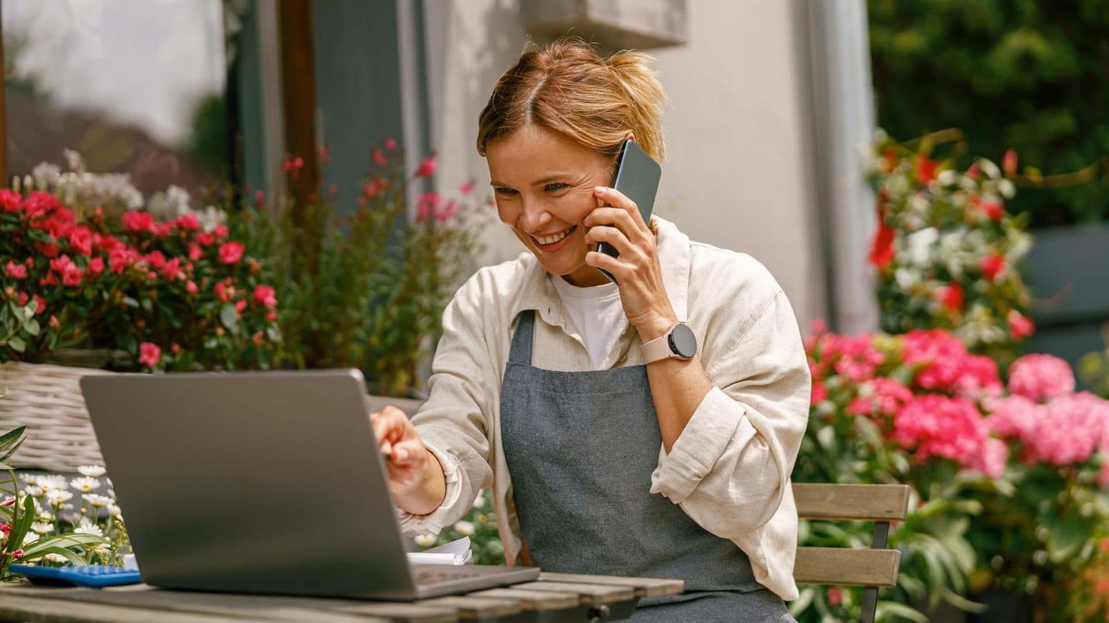 Small business owner comparing her google business profile vs website on a phone and laptop
