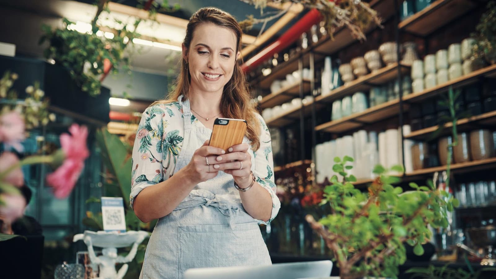 Florist checking her local business website on a phone inside her shop
