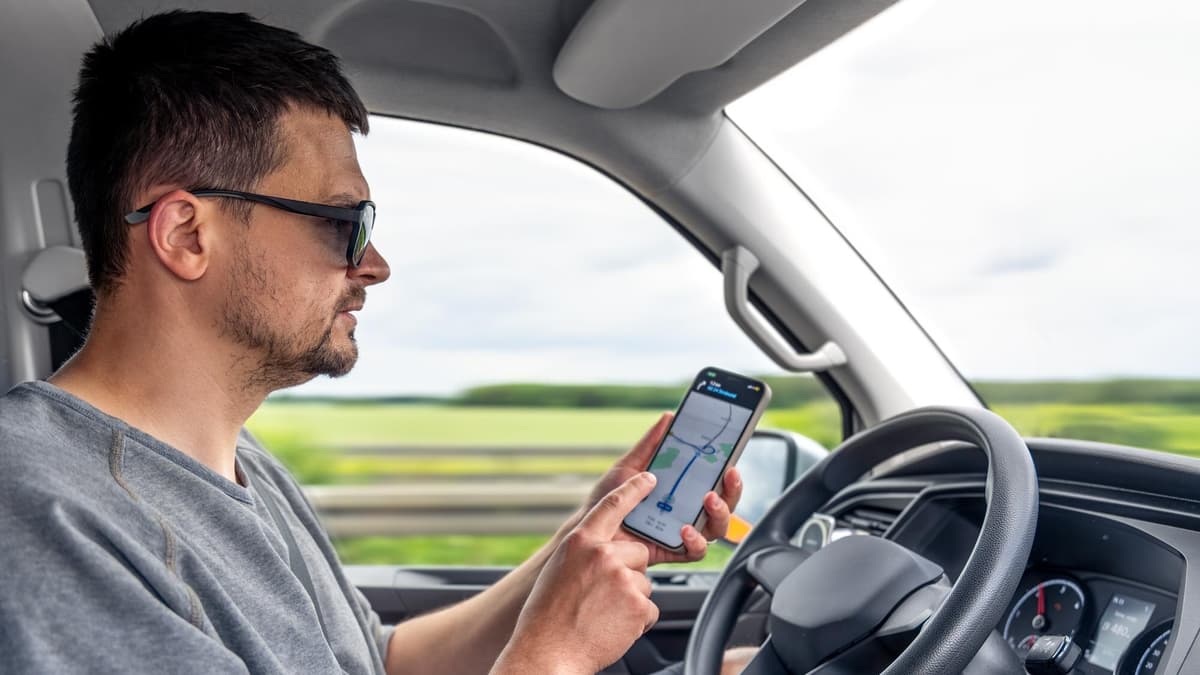 Driver checking directions on a phone before driving to a local business