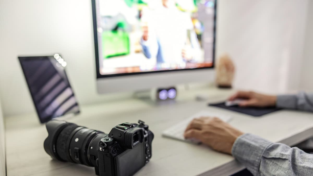 Photographer editing and resizing product photos on a laptop before uploading them to a website