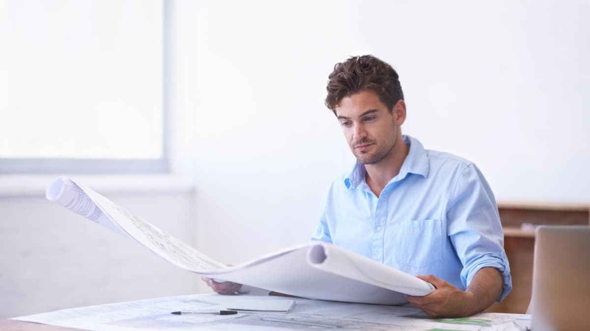 Contractor comparing affordable website design quotes on paper at a job site office