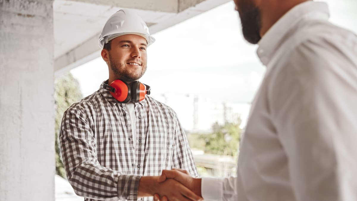 Contractor shaking hands with a happy customer at their front door
