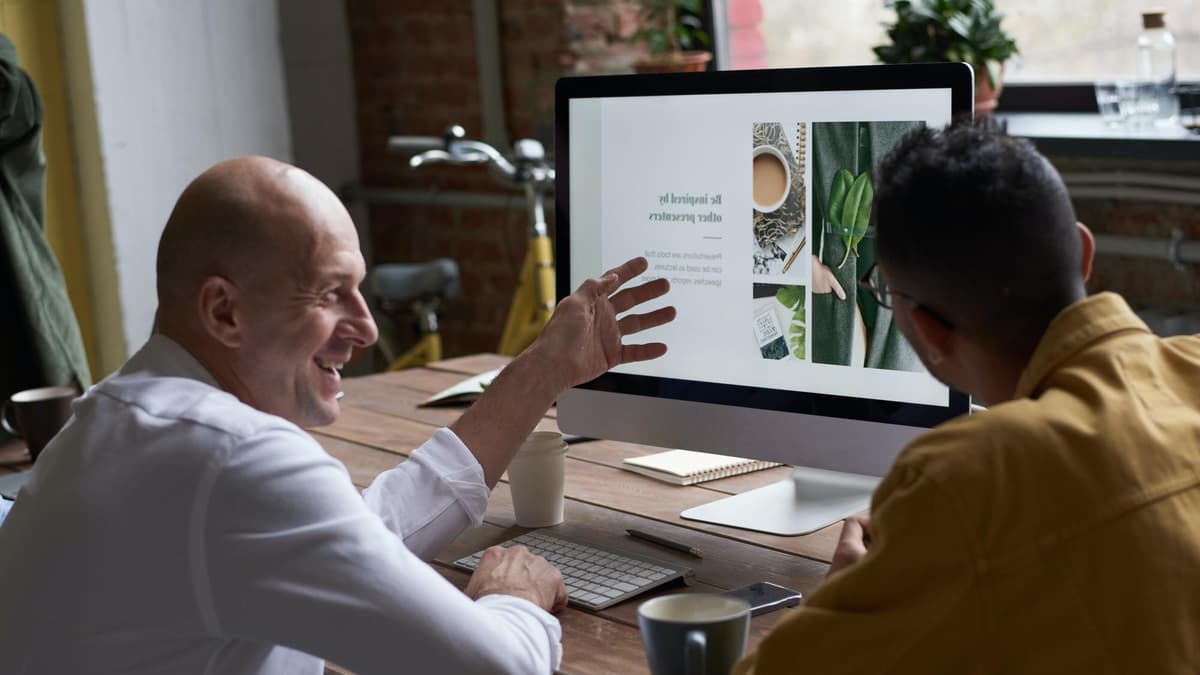 Small business owner and a marketer discussing a website form on a laptop