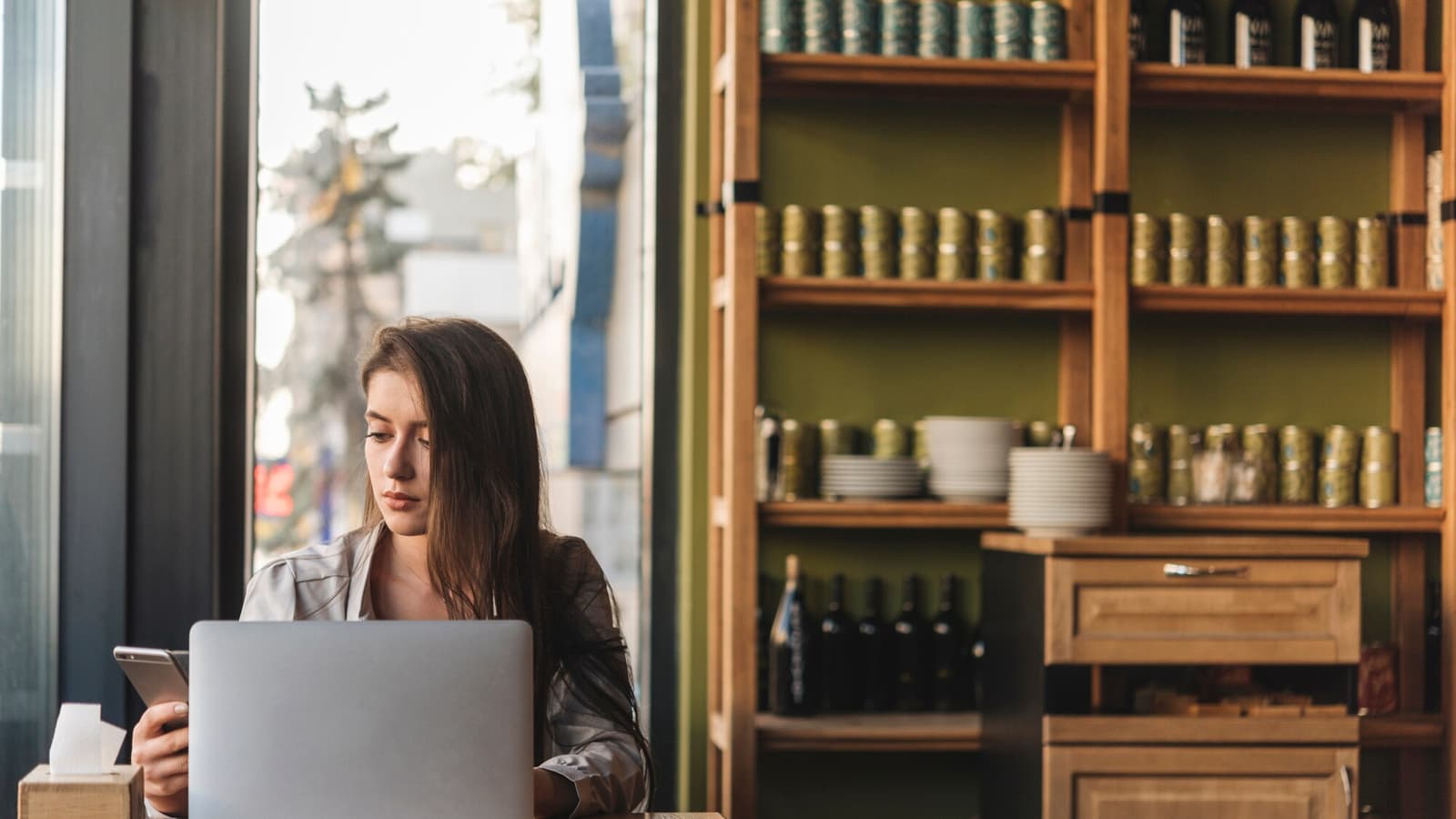 Small business owner checking a laptop behind the counter, the kind of site AI crawlers need to read