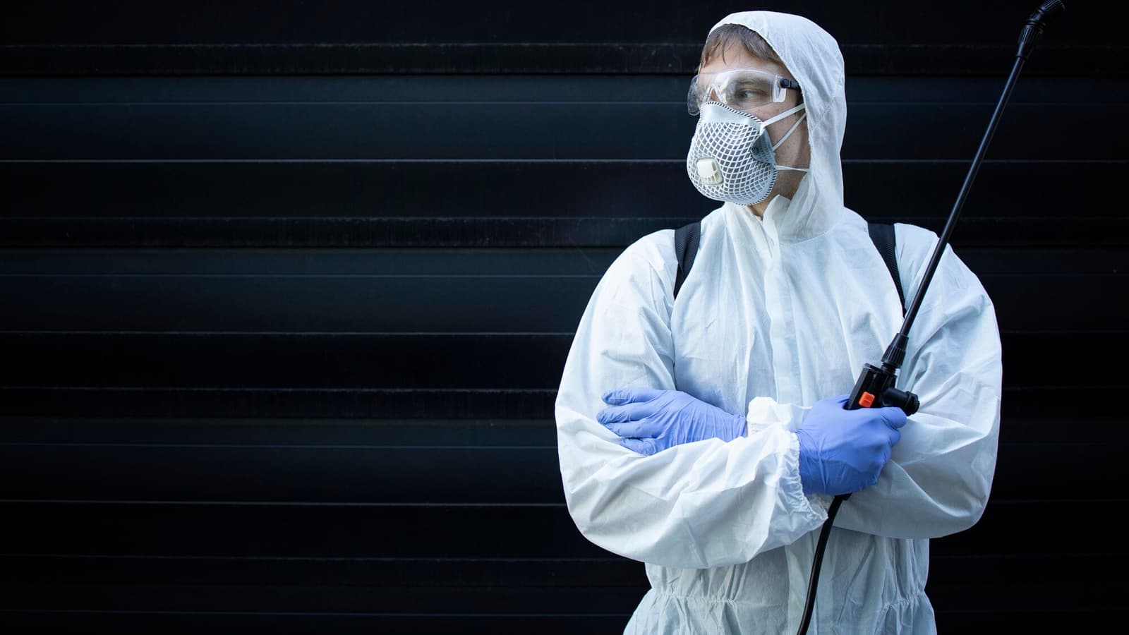 Pest control technician in protective gear ready for a home service call, the job pest control marketing is meant to win