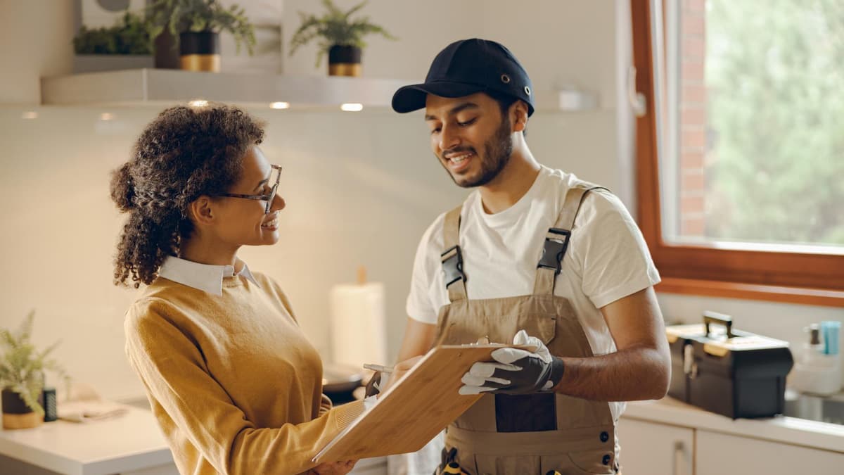 Contractor showing a customer how to leave a review on her phone after finishing a job at her home
