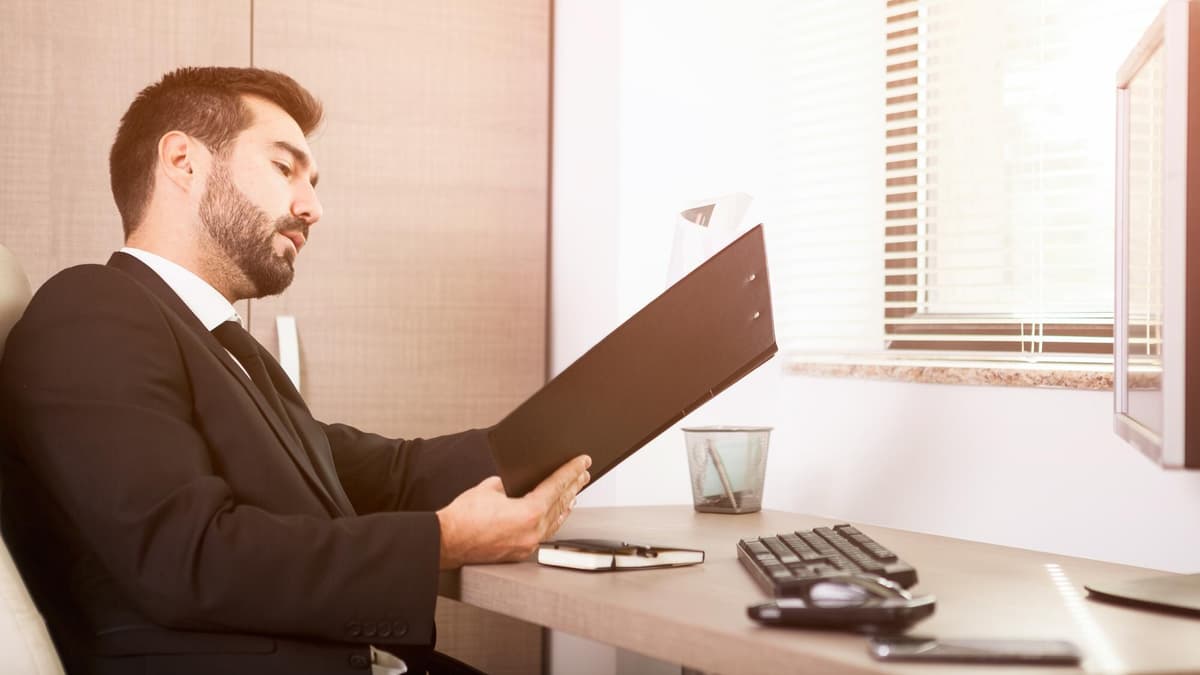 Lawyer reviewing case files at a desk while planning the firm