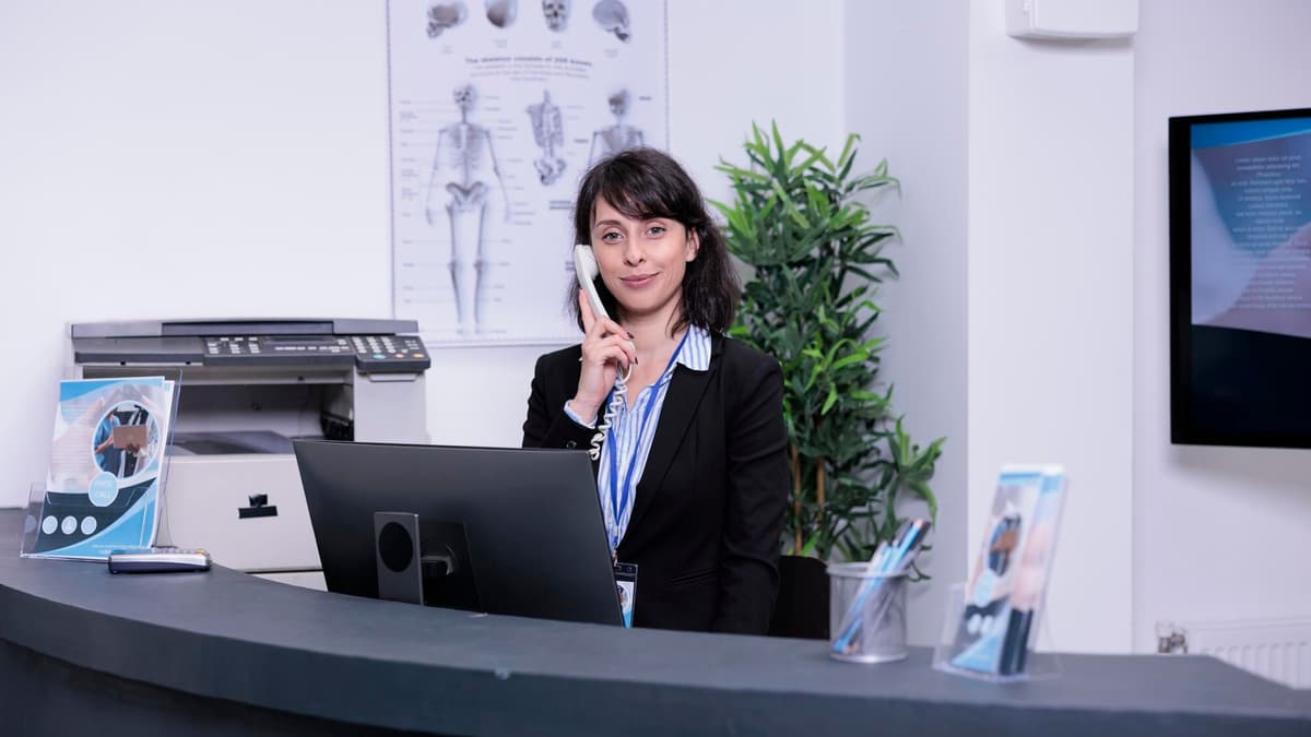 Medical office receptionist answering the phone at the front desk