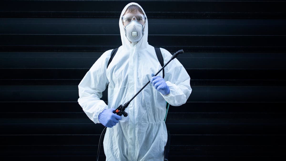 Pest control technician holding spraying equipment before a service visit